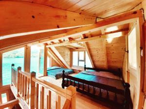 a bedroom in a log cabin with two beds at Lake House Perucac in Rastište