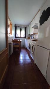 una cocina con lavadora y secadora. en APARTAMENTO CON PISCINA, en Comillas