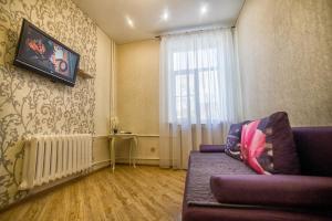 a living room with a couch and a window at Apartment on Kommunisticheskaya in Smolensk