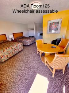 a hotel room with two beds and a television at Dunes Inn Alamosa in Alamosa