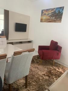 Ed. Odilon Vieira ap.205 في فيتوريا دا كونكيستا: غرفة معيشة مع كرسي احمر وطاولة