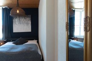 einen Spiegel in einem Schlafzimmer mit einem Bett darin in der Unterkunft Hotel Mamma in Bremgarten