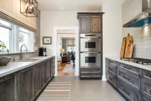 una cocina con armarios de madera y electrodomésticos de acero inoxidable en The Main Street House - Designer Napa Home en Napa