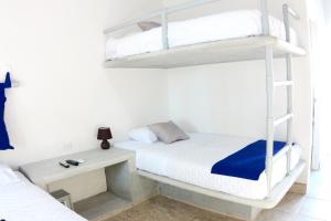 a bedroom with two bunk beds and a desk at Burí Hotel in Monterrico
