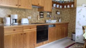 a kitchen with wooden cabinets and a stove at Trollenhof in Wellendingen