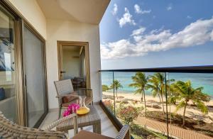 Bamboo的住宿－Royalton Grenada, An Autograph Collection All-Inclusive Resort，一个带椅子的阳台,享有海滩美景