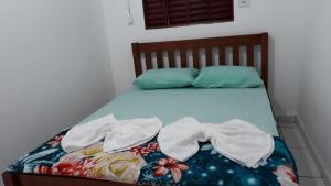 uma cama com duas toalhas em cima em Pousada Vancele em Bonito