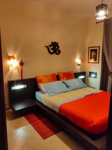 una camera da letto con letto con lenzuola arancioni e cuscini blu di Angolo Relax a Terracina