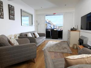 a living room with two couches and a television at 1 At The Beach in Beesands
