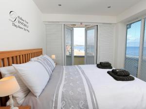 a bedroom with a bed with a view of the ocean at 1 At The Beach in Beesands