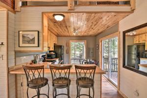 Una cocina con una encimera con taburetes. en Woodsy Cabin Hideaway with Deck Hike, Fish, Escape, en Bordenville