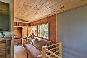 Una sala de estar con un sofá y un televisor. en Woodsy Cabin Hideaway with Deck Hike, Fish, Escape, en Bordenville