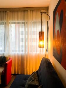 Pokój z lampką, kanapą i oknem w obiekcie Apto. completo na praia de Ponta Verde w mieście Maceió