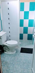 uma casa de banho com WC e piso em azulejo em Gloria's Hotel em Playa Estacahuite