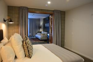 a bedroom with a bed and a living room at Southwark Hotel & Apartments in Christchurch