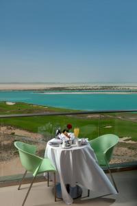 - une table avec une assiette de nourriture et une vue sur l'océan dans l'établissement Crowne Plaza Yas Island, an IHG Hotel, à Abu Dhabi