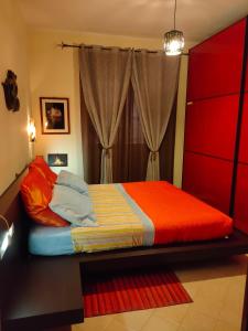 una camera con letto con lenzuola rosse e gialle di Angolo Relax a Terracina