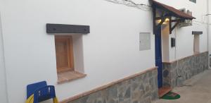 een wit gebouw met een deur aan de zijkant bij La Casita Azul in Alora
