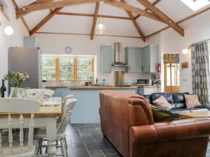 a kitchen and living room with a couch and a table at The Old Haybarn in Newton Abbot