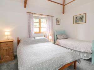 a bedroom with two beds and a window at The Old Haybarn in Newton Abbot