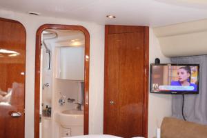 a bathroom with a tv in the corner of a room at Porto Private Yacht- Accommodation Douro River in Porto