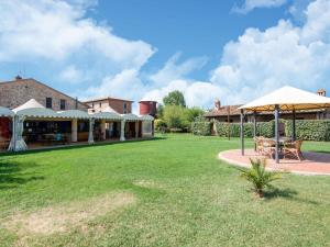 PucciarelliにあるLarge Farmhouse in Castiglione del Lago with Poolの庭園内のパティオ(テーブル、傘付)