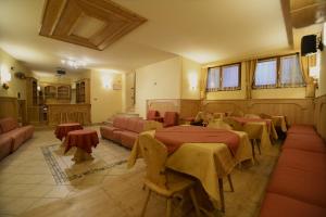 una grande stanza con tavoli, divani e finestre di Albergo Valbella a Gallio