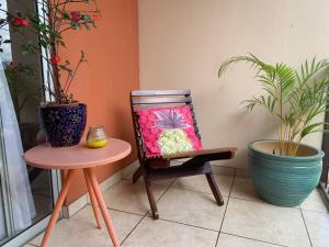 a table with a flower pot sitting on top of it at Casa de Lis Hotel & Tourist Info Centre in Turrialba