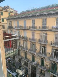 ナポリにあるAlexander hostelのバルコニー付きの建物と通りの景色を望めます。