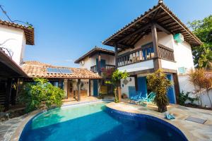 a villa with a swimming pool in front of a house at Vila Bela-Emília in Búzios