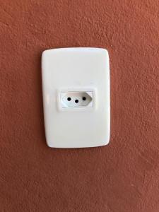 a white switch on a brown wall at Casas de Juan in Morro de São Paulo