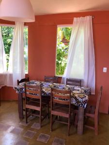 una sala da pranzo con tavolo e sedie e due finestre di Casas de Juan a Morro de São Paulo