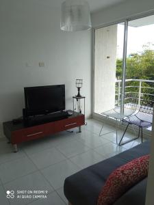 a living room with a flat screen tv on a cabinet at CH3 Moderno apartamento amoblado en condominio RNT-1O8238 in Valledupar