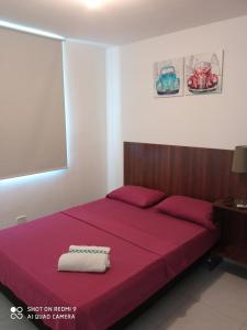 a bedroom with a bed with a red bedspread at CH3 Moderno apartamento amoblado en condominio RNT-1O8238 in Valledupar