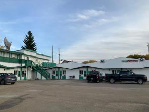 a parking lot with trucks parked in front of a building at Bio Vista Motel in Wainwright