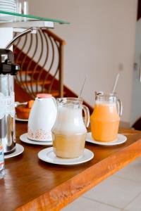 two mason jars of milk and orange juice on a counter at Shalom Pousada Capitólio in Capitólio