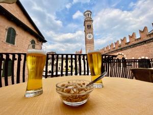 una mesa con dos vasos de cerveza y un tazón de nueces en Hotel Aurora, en Verona
