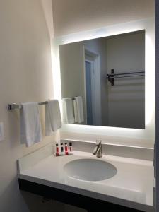 a bathroom with a sink, mirror, and towel rack at Motel 6 Vallejo, CA - Napa Valley in Vallejo