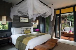 a bedroom with a large bed and a patio at Anantara Lawana Koh Samui Resort in Chaweng