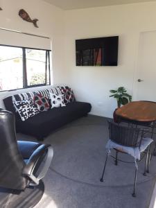 uma sala de estar com um sofá e uma mesa em Te Puru Holiday Park em Thames