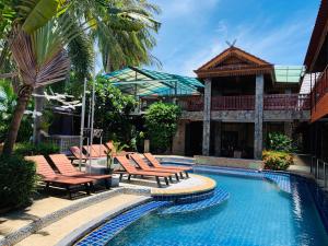 a swimming pool with lounge chairs and a house at Delight Resort in Haad Rin