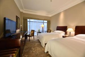 pokój hotelowy z 2 łóżkami i telewizorem z płaskim ekranem w obiekcie Hotel Equatorial Shanghai w Szanghaju