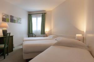 a hotel room with three beds and a window at Hôtel de l'Orme, Akena in Évreux +18 photos