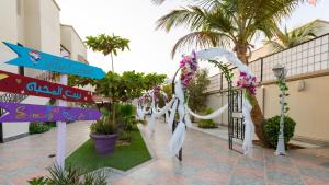 a corridor of a hotel with signs and flowers at B-LBAIT Yanbu Villa Garden in Madīnat Yanbu‘ aş Şinā‘īyah