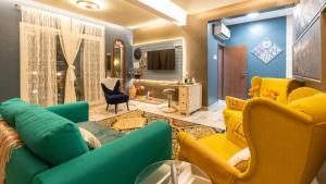 a living room with a green couch and yellow chairs at B-LBAIT Yanbu Villa Garden in Madīnat Yanbu‘ aş Şinā‘īyah