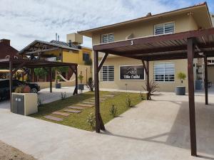 ein Haus mit einem Parkplatz mit Terrasse in der Unterkunft Complejo Villa Calitri in Villa Gesell