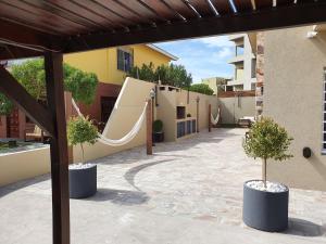 a patio with a slide and two potted trees at Complejo Villa Calitri in Villa Gesell