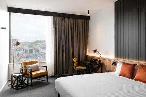 朗塞斯顿Hotel Verge Launceston的一间带床、桌椅的酒店房间