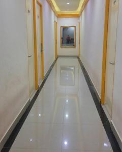 a hallway with a white floor and a mirror at Gold Line Guest House in Pontianak