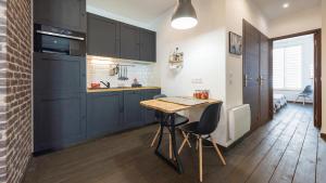Una cocina con gabinetes azules y una mesa de madera. en L'Atelier fil à fil, en Le Mans 9 fotos más